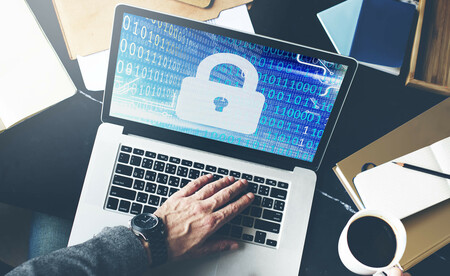 Laptop computer showing security-focused interface with padlock icon and binary code visualization